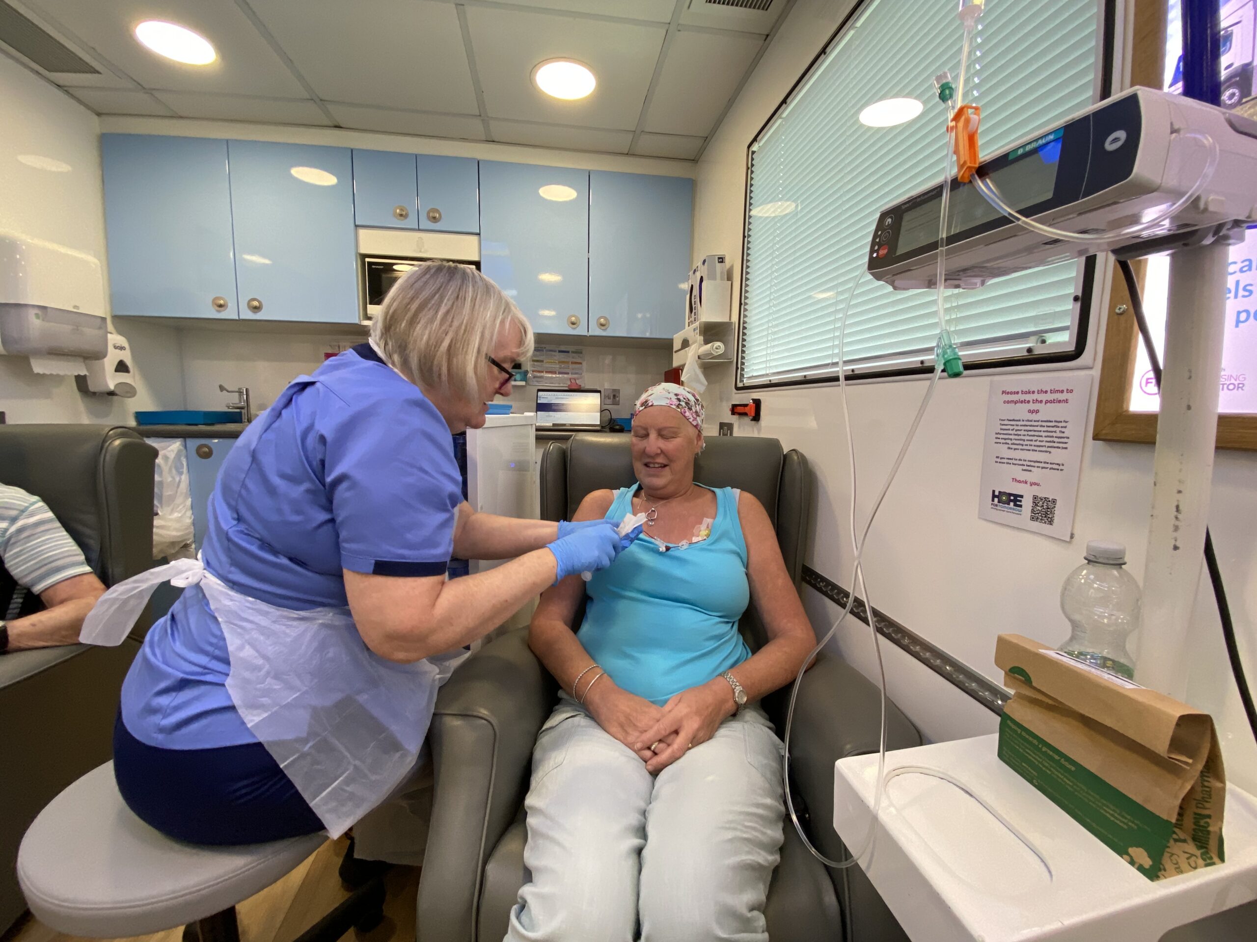 Linda Venton with nurse Denise Linda Venton sitting in a chemotherapy chair with a nurse by her side