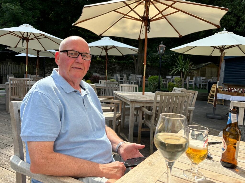 Robin Hebden sat at a table outdoors enjoying his holiday.