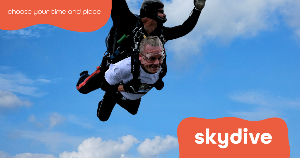 John, a man in his early 40s, jumping from a plane attached to an instructor, wearing his Hope for Tomorrow branded t-shirt