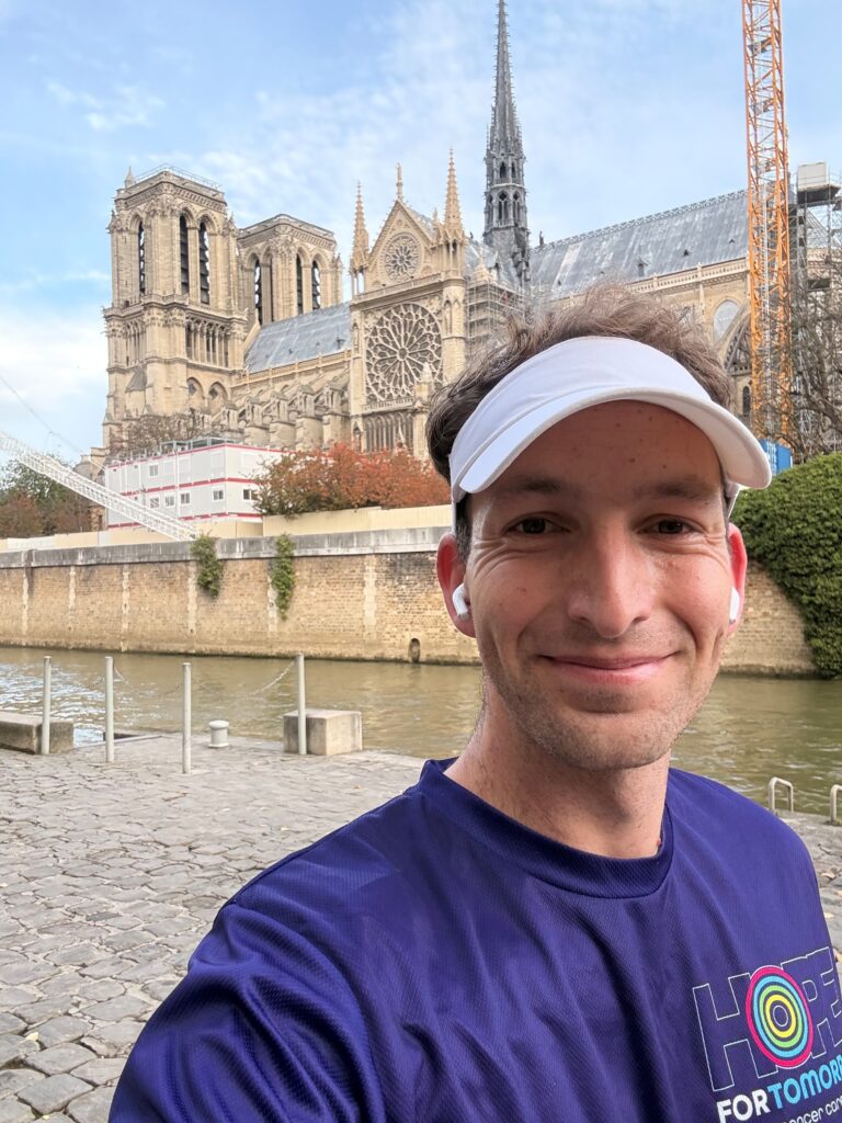 Luke sat in a hospital chair in a hospital gown after going through surgery