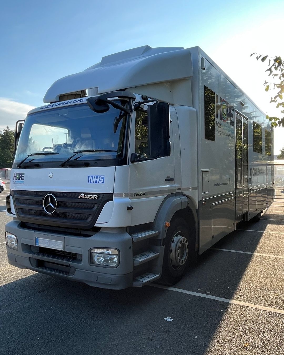 An image showing a Hope for Tomorrow mobile unit parked in a supermarket car park